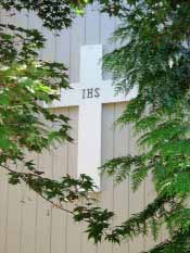 The eloquently simple IHS cross above the Saint Gerard's entrance. The IHS symbol consists of the first three letters of a Greek word for Christ, the anointed one, the messiah. Suzanna Wright photo.